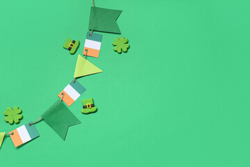 Paper garland with Irish flags for St. Patrick's Day celebration on green background