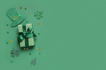 Gift box with leprechaun hat, clovers and sequins for St. Patrick's Day celebration on green...