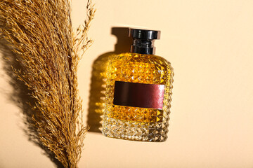 Bottle of perfume with pampas grass on beige background. Top view