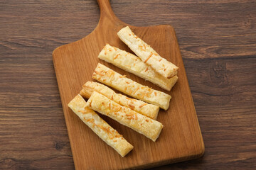 Cheese Stick Pastry served on chopping board
