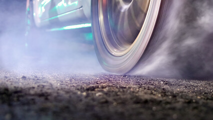 EV Drag racing car is burning tires at start line.