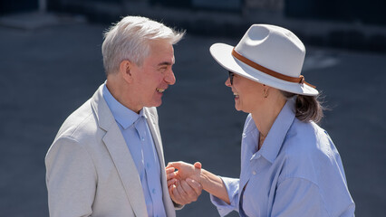 Stylish elderly laughing couple on a walk. Romantic relationships of mature people. 