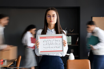 Young business woman with evacuation plan in office