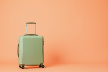 a green suitcase is sitting on a pink background