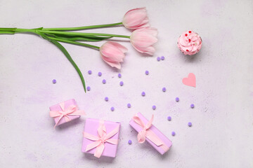 Presents, pink tulips and cupcake on light background