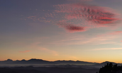 Nuvola rossa sopra le montagne al tramonto