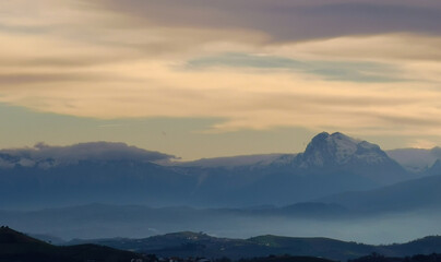 Le cime dei monti le colline e le valli immerse in una luce nebbiosa 