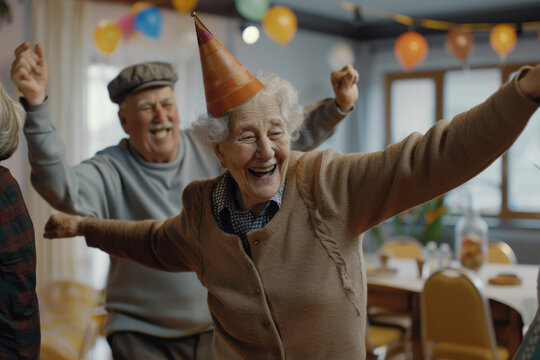 Smiley seniors dancing and having fun celebrating birthday in nursing home