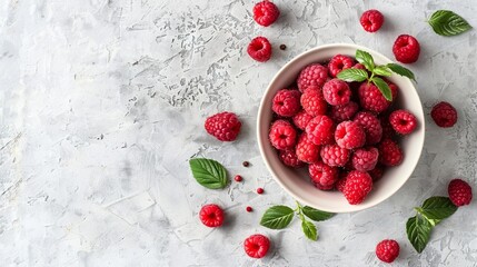 A bowl of vibrant raspberries arranged neatly on a white table