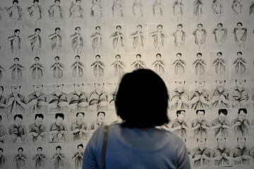 Woman looking at monochrome artwork.