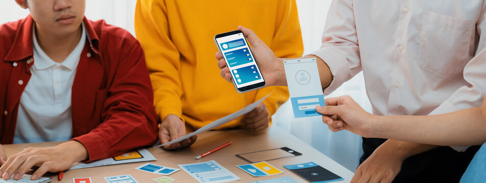 Panorama banner of startup UX developer or company employee design user interface or UI prototype for mobile application or website software with software display on smartphone in office. Synergic