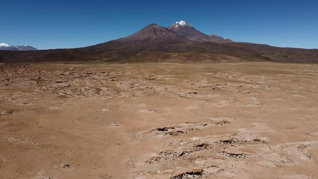 Flyover volcanic fumaroles toward distant snow peak mountain, Bolivia