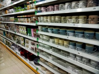 colourful ceramic glasses on shelves in supermarket