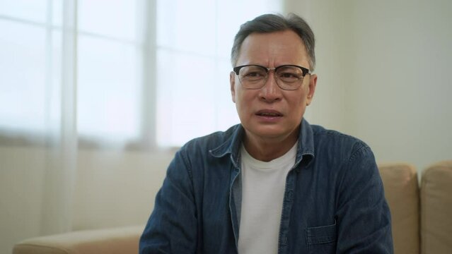 Upset asian senior man worried about problem, unhappy elder man feeling annoyed with health problem, retired man thoughtful confused memory problem.
