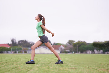 Sports, stretching and woman on field for exercise, workout and training for running outdoors. Fitness, park and person warm up for wellness, healthy body and exercising for performance and balance