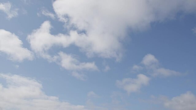 Cotton clouds move over the blue skies