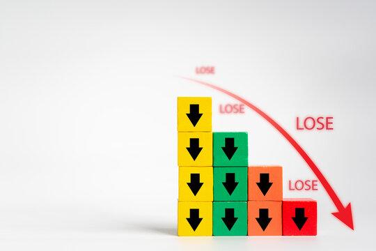 Discover the indicator of an economic crisis through a wooden block displaying a volume decrease icon and red arrow, symbolizing business deficit and financial downfall
