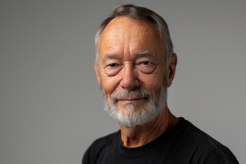 Obraz premium Portrait of a senior man with grey hair and beard on grey background