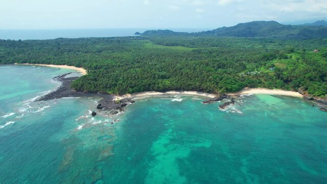 Aerial view from the South Coast of Sao Tome, with amazing beaches and turquoise sea,with the forest as background,Africa. Circular drone shot