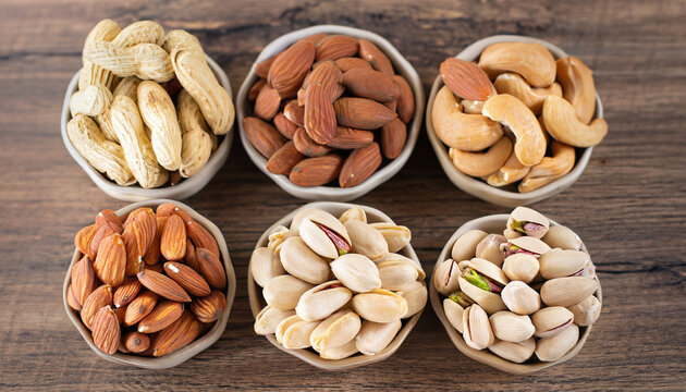Healthy mix nuts on wooden background. Almonds, hazelnuts, cashews, peanuts, Brazilian nuts