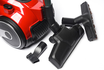 Red modern vacuum cleaner with attachments on a white background - obrazy, fototapety, plakaty