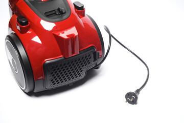 Red vacuum cleaner with electric plug on white background