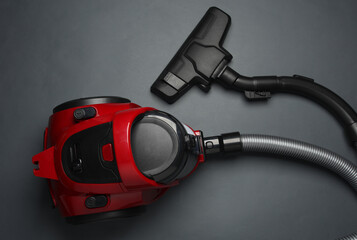 Red vacuum cleaner on a dark background. Top view