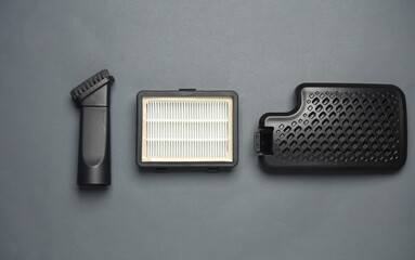 Vacuum cleaner filter and brush on a dark background