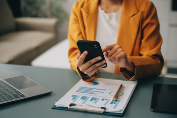 Asian businesswoman in formal suit in office happy and cheerful during using smartphone and working