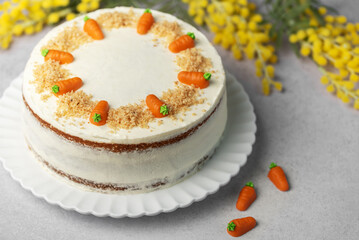 Homemade carrot cake made with walnuts, iced with cream cheese. Sweet dessert.