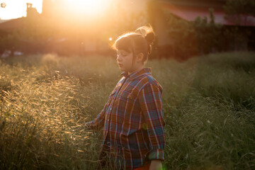 Cute little girl having fun in a poppy field in magic sunset.