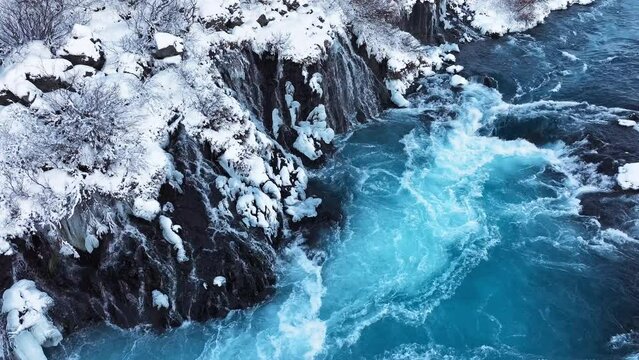 Pure turquoise water, glacial river with huge current, Waterfall in Iceland, Frozen waterfall in winter, magical winter location of snow and ice, Popular tourist attraction