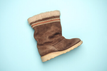 Children's suede boot with fur on blue background