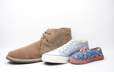 Father, mother and child's shoes on white background.