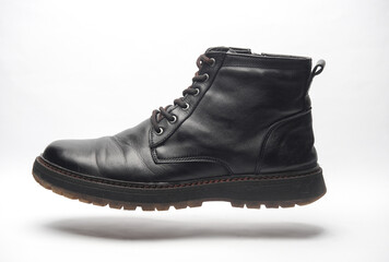 Black leather men's boot floating on a white background