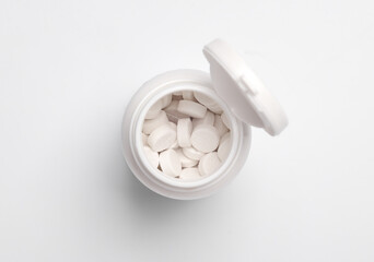 Plastic jar of pills on white background. Top view