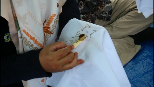 Asian woman painting Batik Tulis.