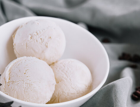 Vanilla ice cream balls on white bowl