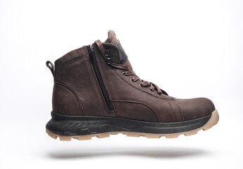 Brown leather boot floating on white background