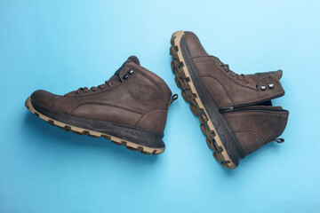 Pair of Brown leather boots on blue background. Top view