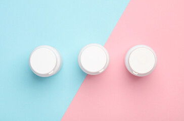 Plastic white pill bottles on pink blue background. Top view