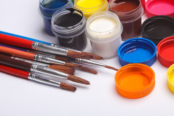 Set of gouache paints in bottles with brushes on a white background. Children's creativity