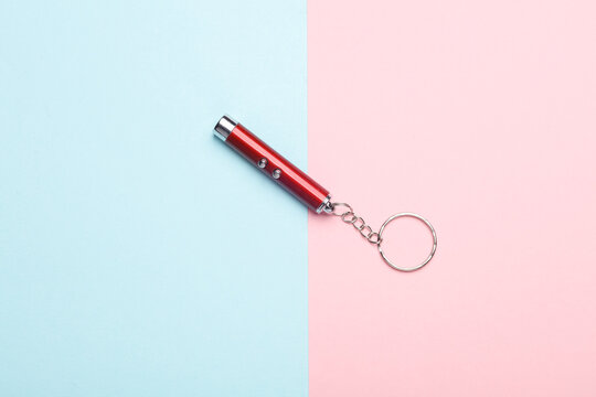 Laser pointer flashlight on pink blue background