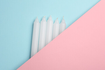 Wax candles on pink blue background