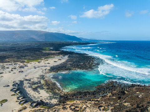 Landscape with turquoise ocean water on Caleta del Mojon Blanco in Lanzarote, Canary Islands, Spain