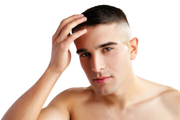 Young man standing shirtless and touching his face with hands