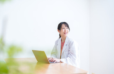 パソコン作業をする女性医師