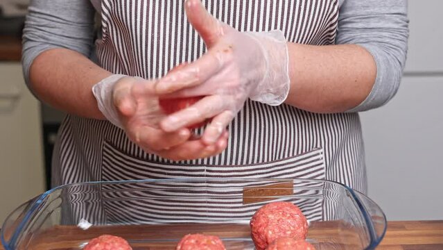 The cook prepares meatballs from minced meat. Preparation of homemade meatballs.