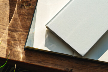 Books by the window on wooden background in sunlight