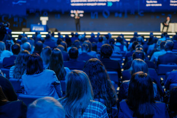 Attentive audience listening to a speaker at a corporate seminar. Capturing learning and...
